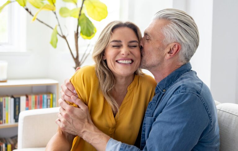 Loving man kissing his wife at home and looking very happy smiling